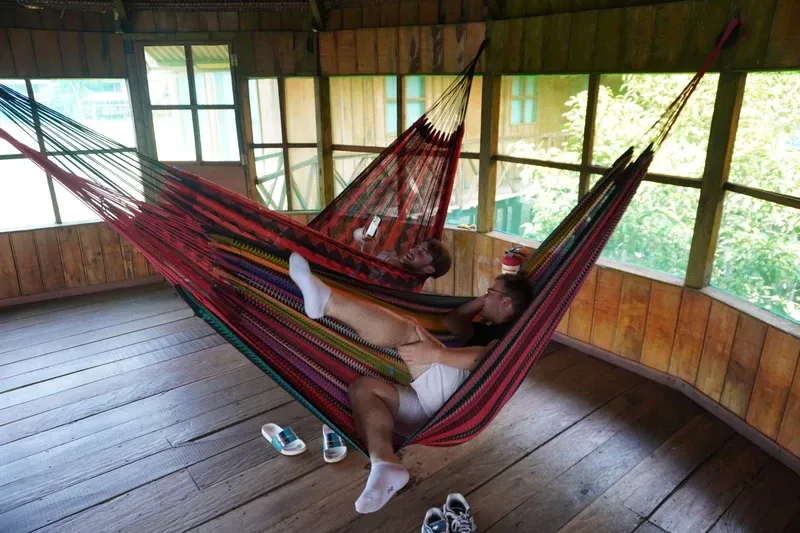 Hammocks beside Lake Zacambú with travelers playing | Amazon Jungle Trips