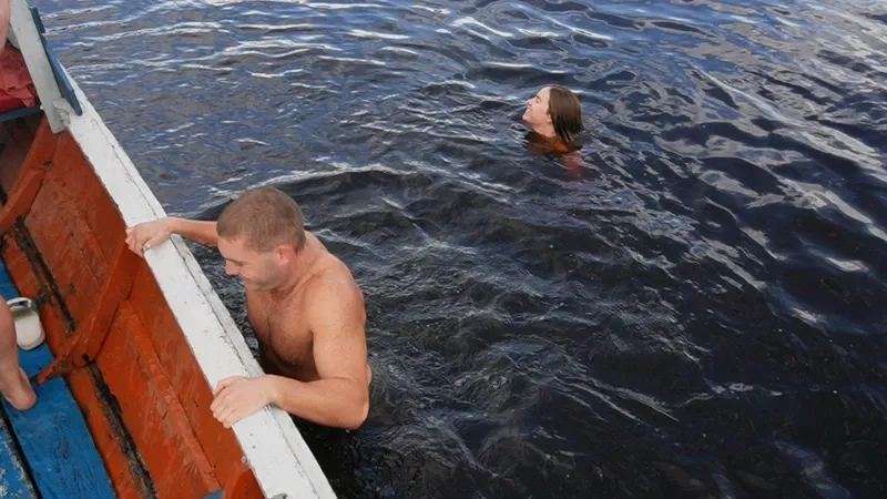 Travelers getting out of the water into a boat on Lake Zacambú | Amazon Jungle Trips